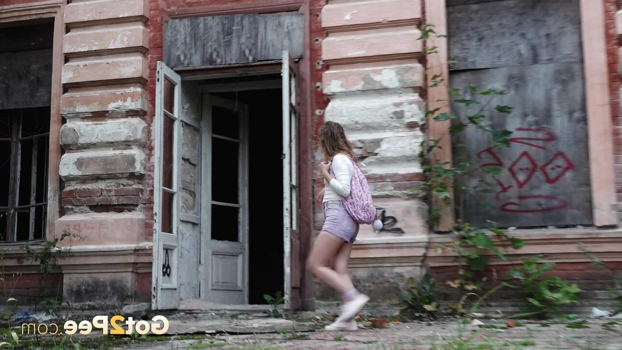 15P Caucasian girl Rita takes a badly needed pee out front of a derelict building