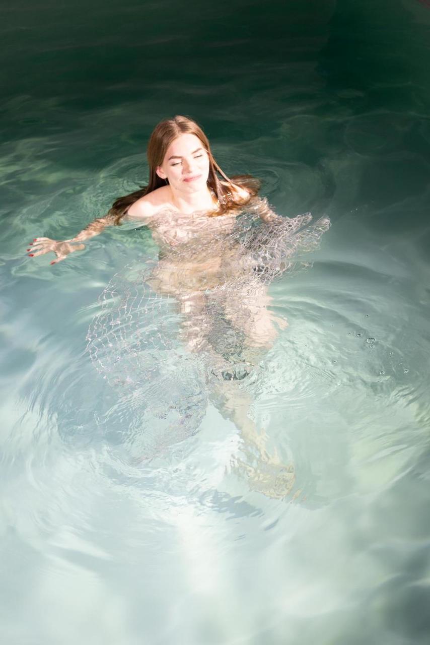 20P La modelo de ojos azules Liza Free posa desnuda y con un vestido transparente en la piscina