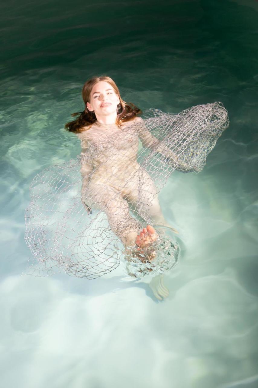 20P La modelo de ojos azules Liza Free posa desnuda y con un vestido transparente en la piscina