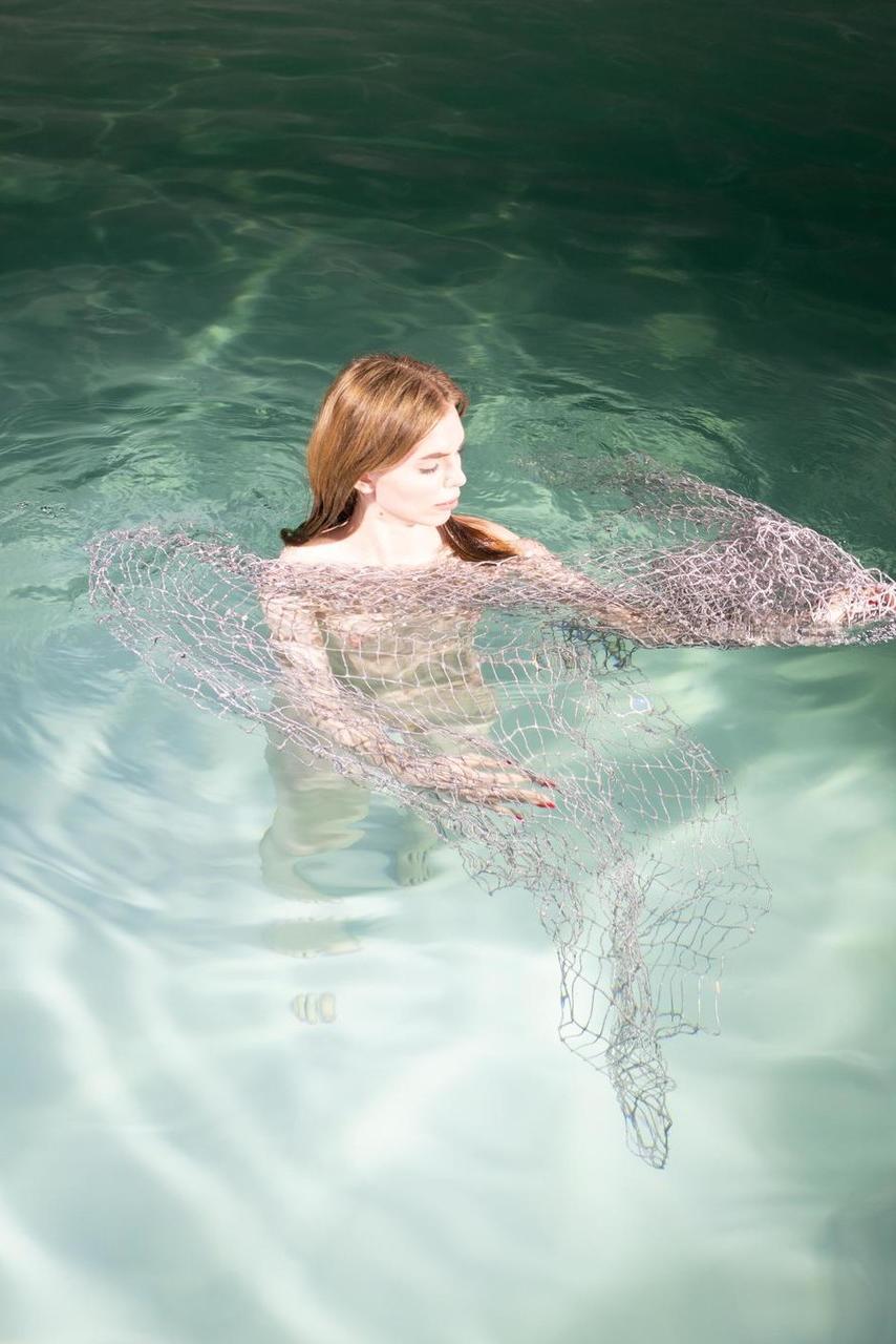 20P La modelo de ojos azules Liza Free posa desnuda y con un vestido transparente en la piscina