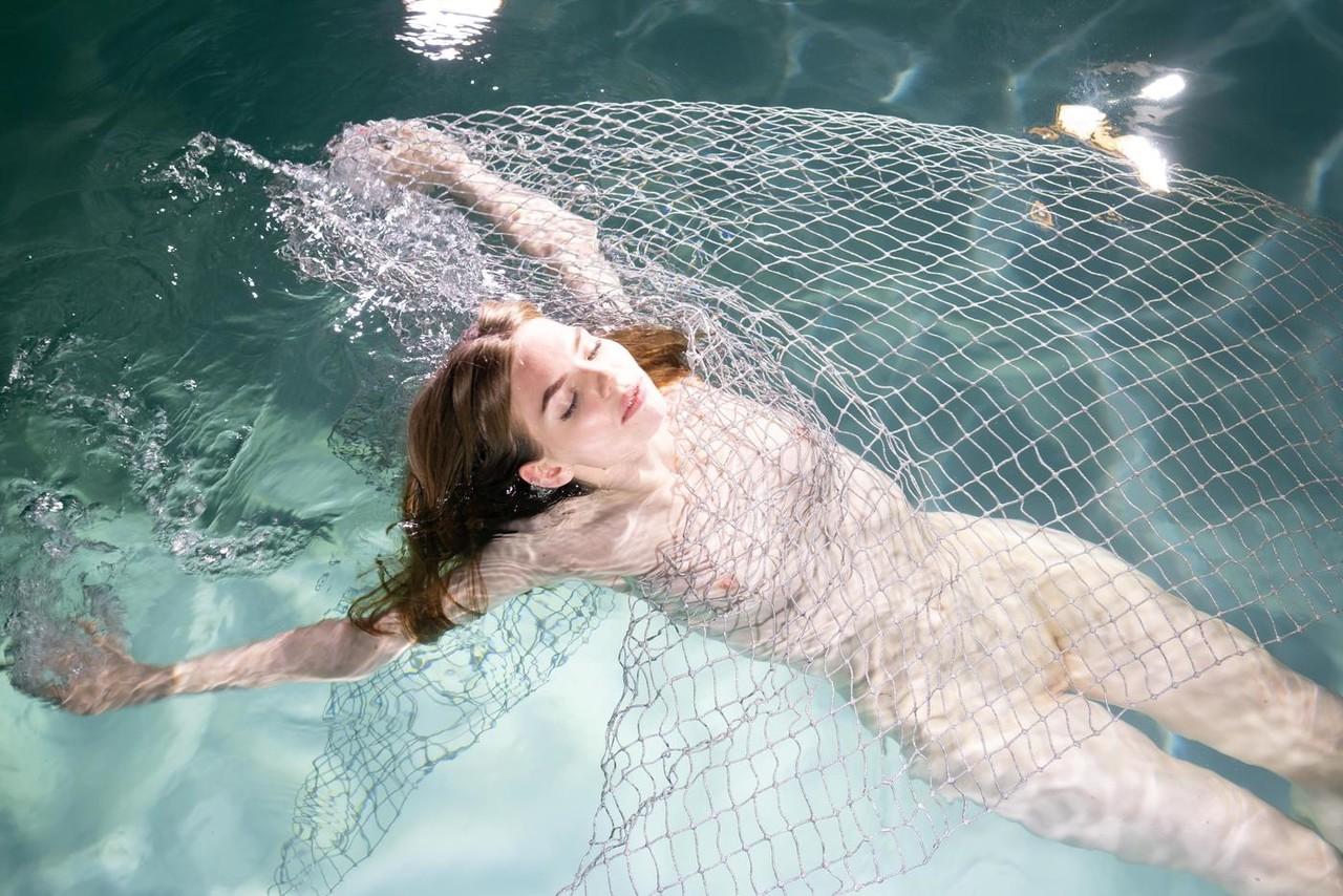20P La modelo de ojos azules Liza Free posa desnuda y con un vestido transparente en la piscina