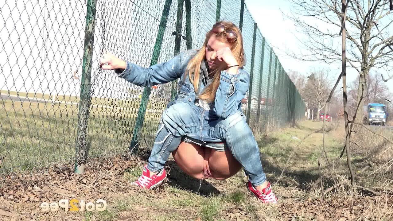 15P La chica blanca Chrissy orina muy necesaria junto a una valla metálica