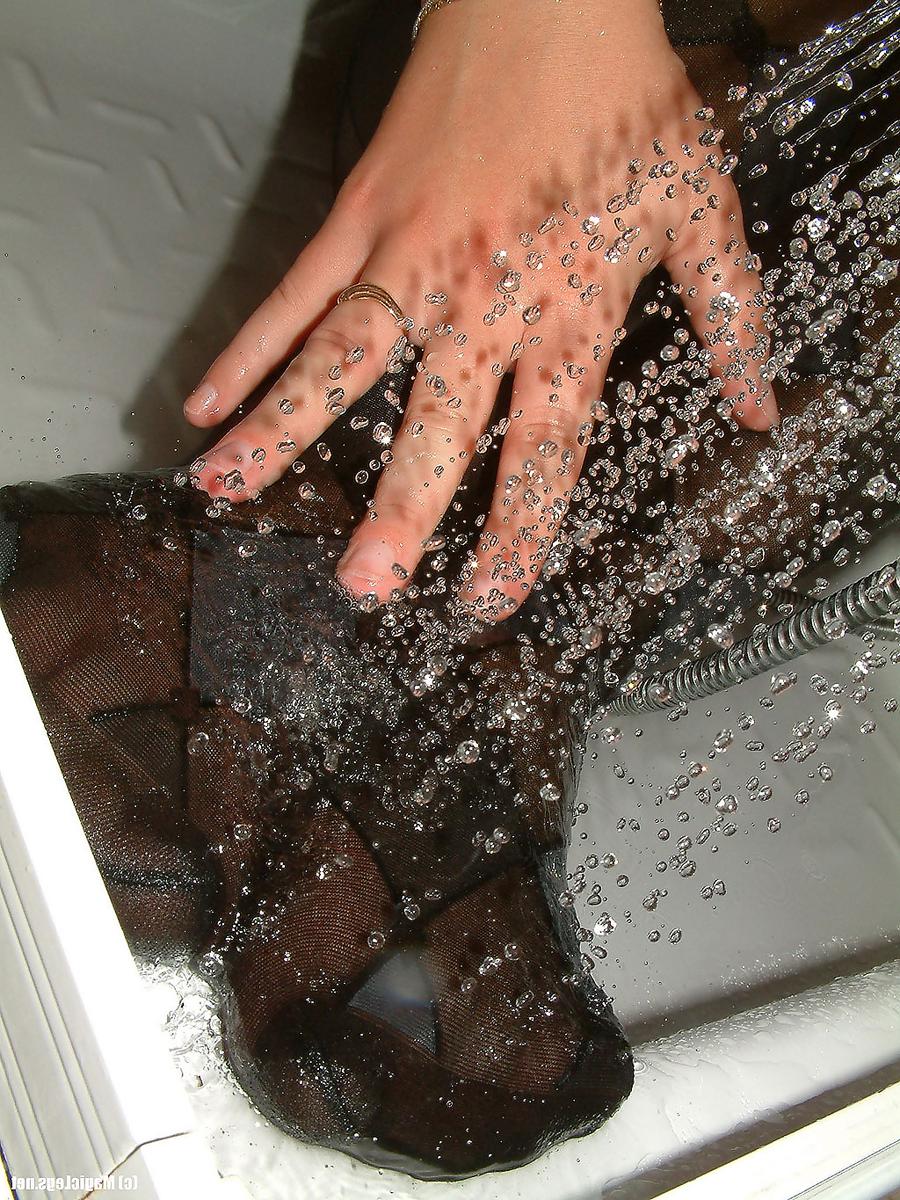 16P La brune sexy Kasia mouille ses collants arlequins dans une salle de bain.