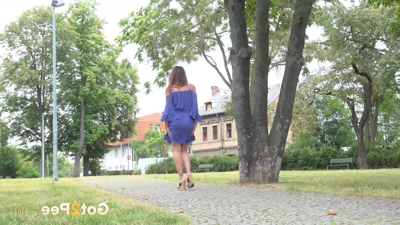 15P La chica caucásica Yenna orina cerca de un muro de piedra durante el día