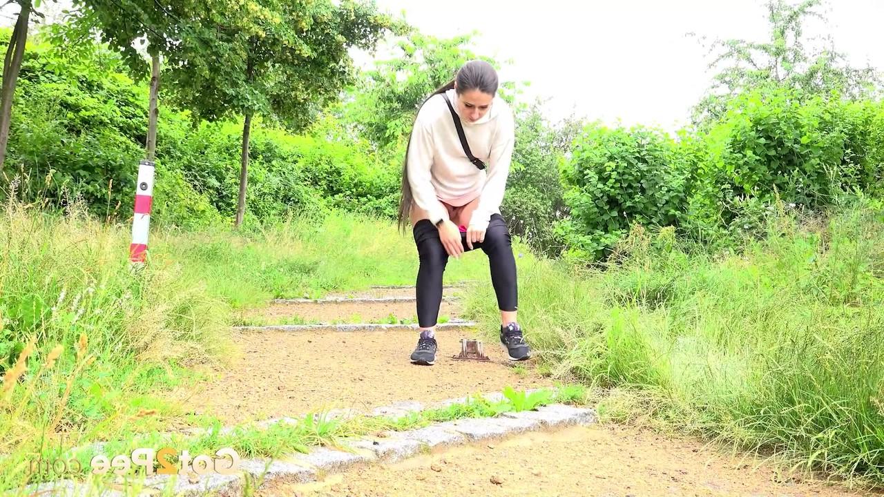 15P Lara Fox, de pelo largo, se baja las mallas negras para orinar en un sendero
