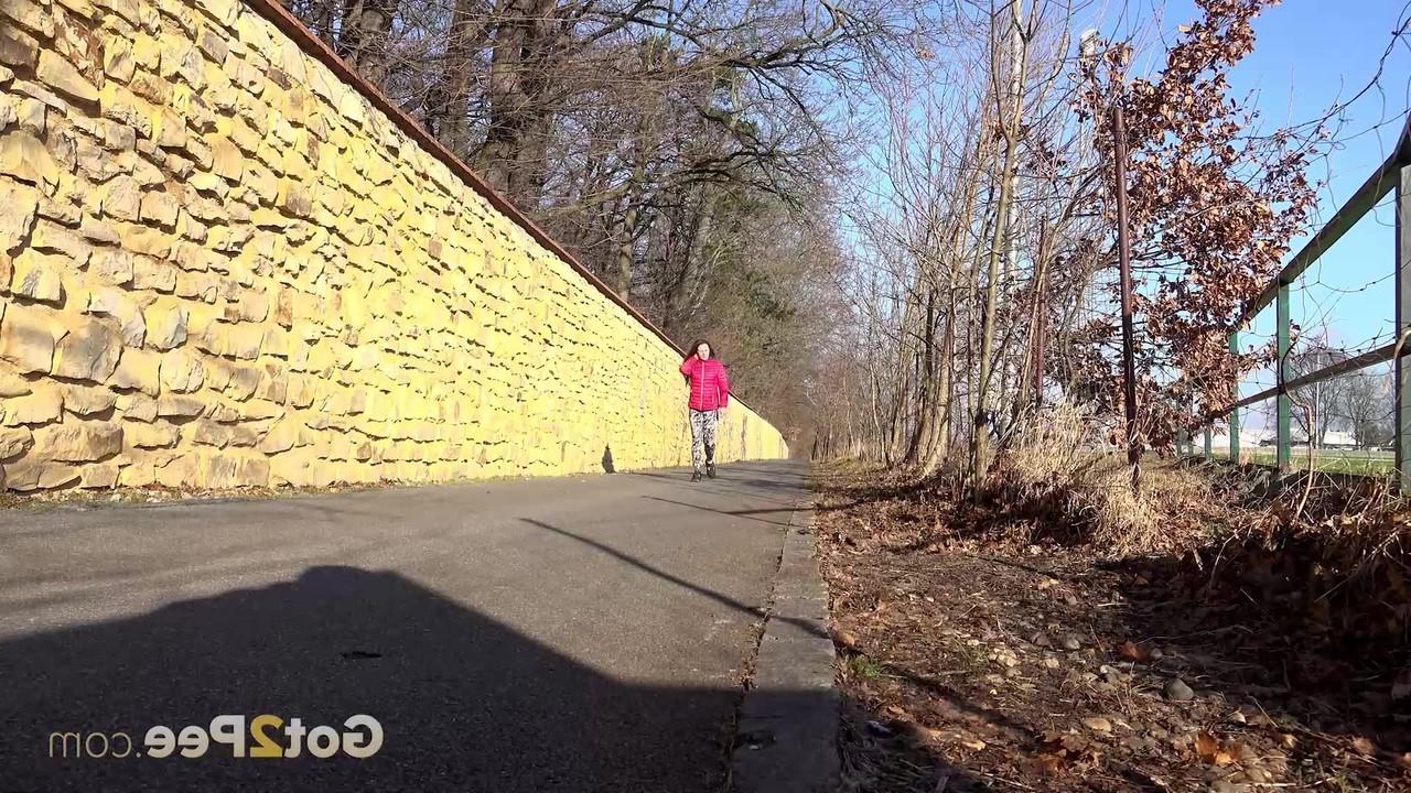 15P A garota caucasiana Valentina Ross faz xixi em uma estrada pavimentada durante o dia