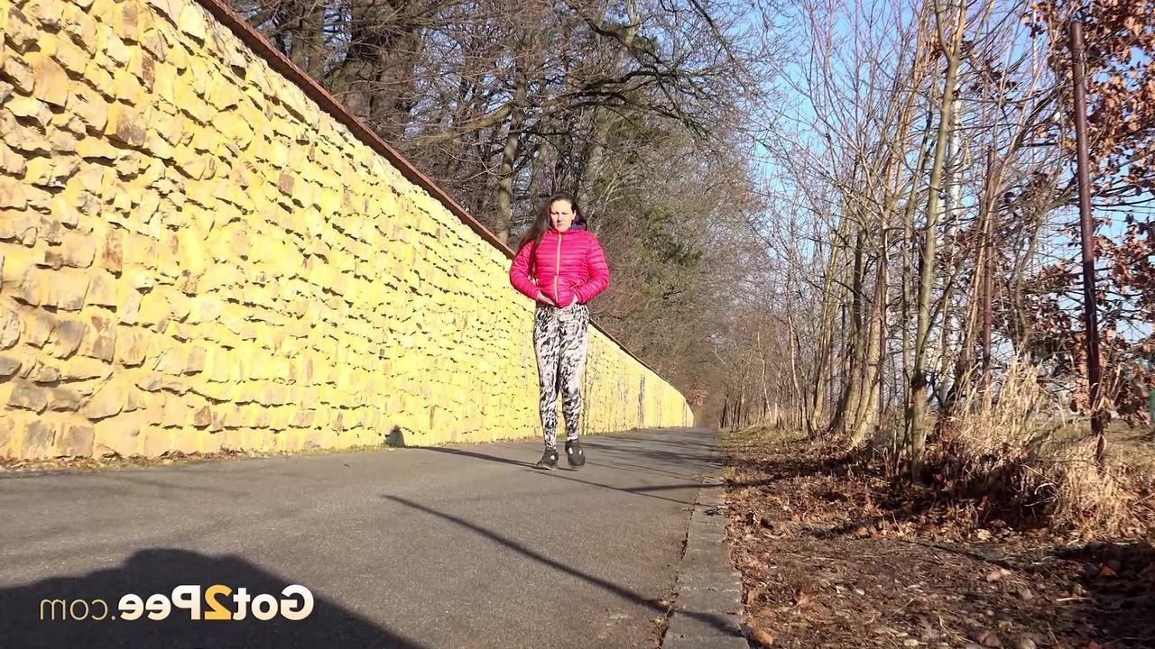 15P A garota caucasiana Valentina Ross faz xixi em uma estrada pavimentada durante o dia