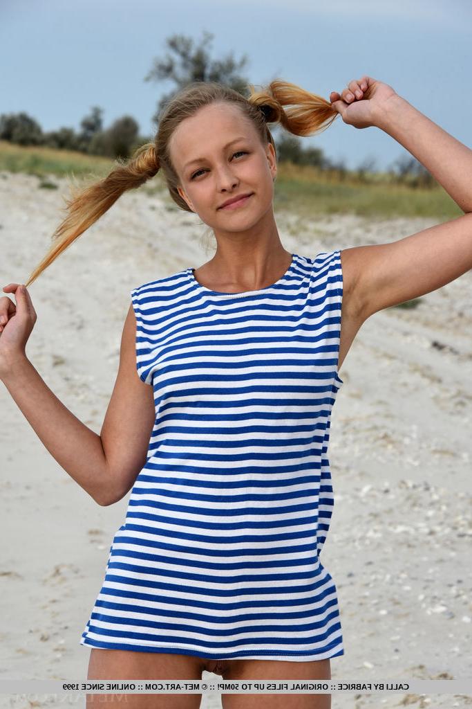 18P Teen model Calli tugs on her pigtails while getting naked on a beach