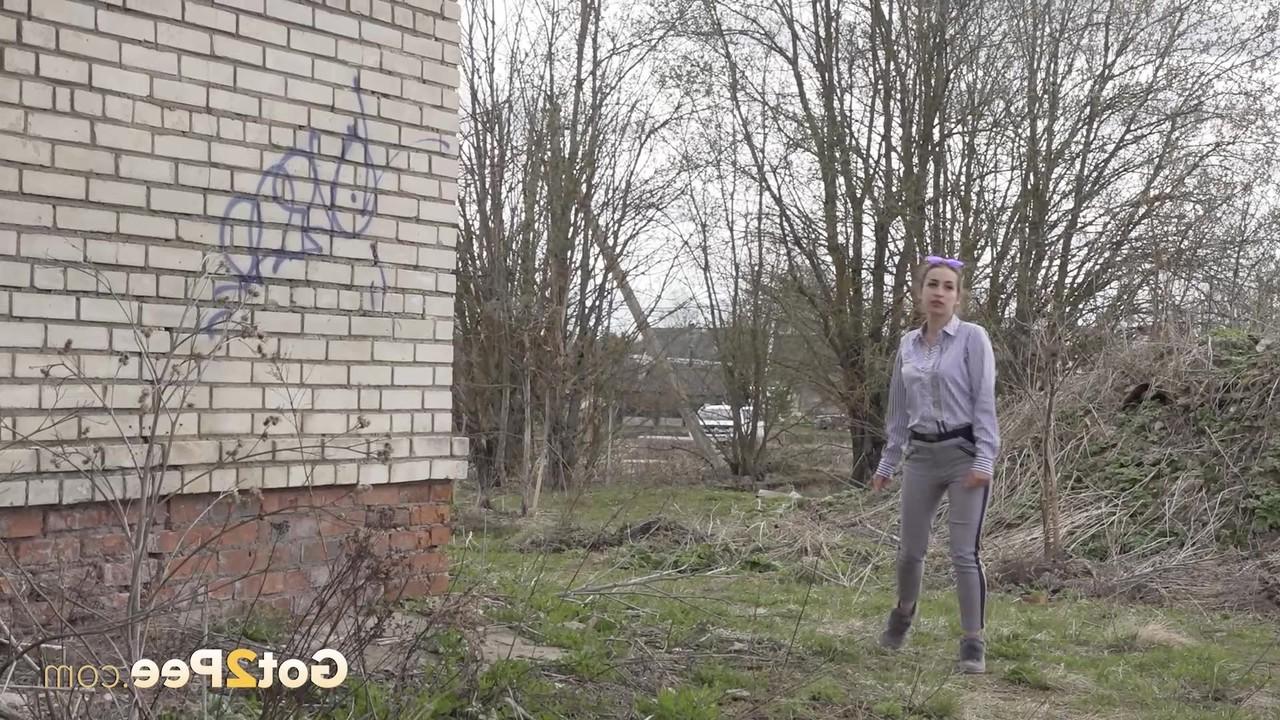 15P Solo girl takes a much-needed piss in the doorway of an abandoned dwelling