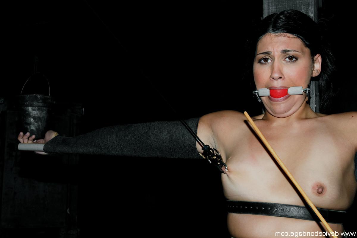 20P Miss Jade Indica, bâillonnée par une boule, subit un serrage douloureux du téton dans un bondage métallique