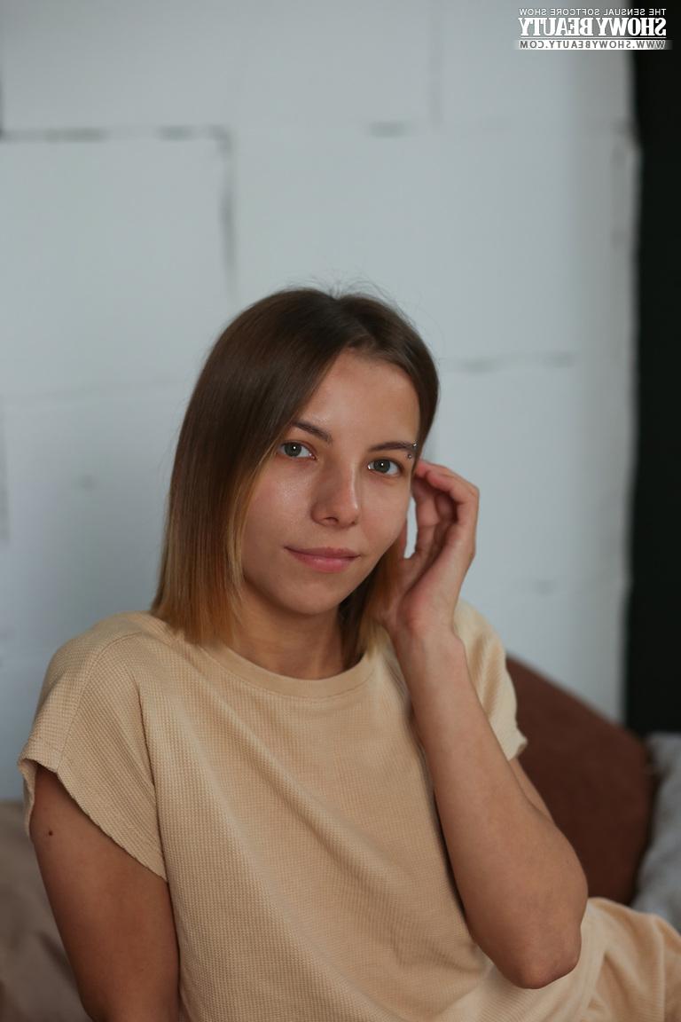 20P La jolie jeune Julie croise ses jambes nues tout en se mettant totalement nue sur un lit.