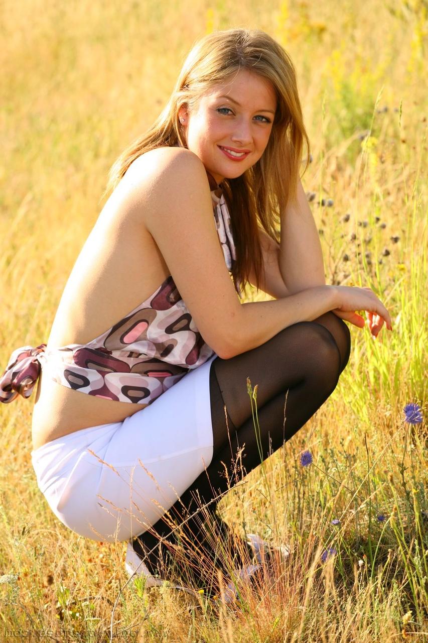 20P La sexy joven amateur Nikki F se pone en cuclillas mientras posa en tanga en el campo