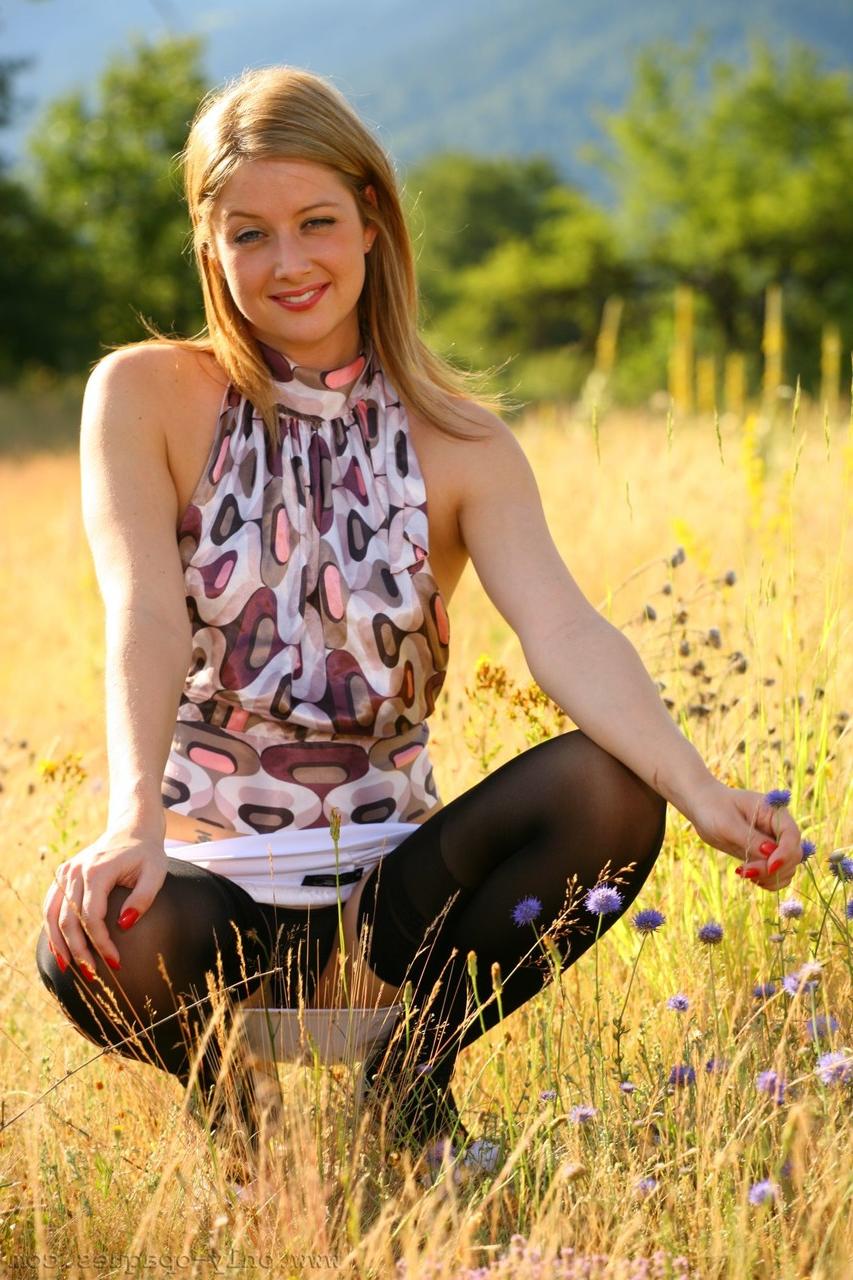 20P La sexy joven amateur Nikki F se pone en cuclillas mientras posa en tanga en el campo