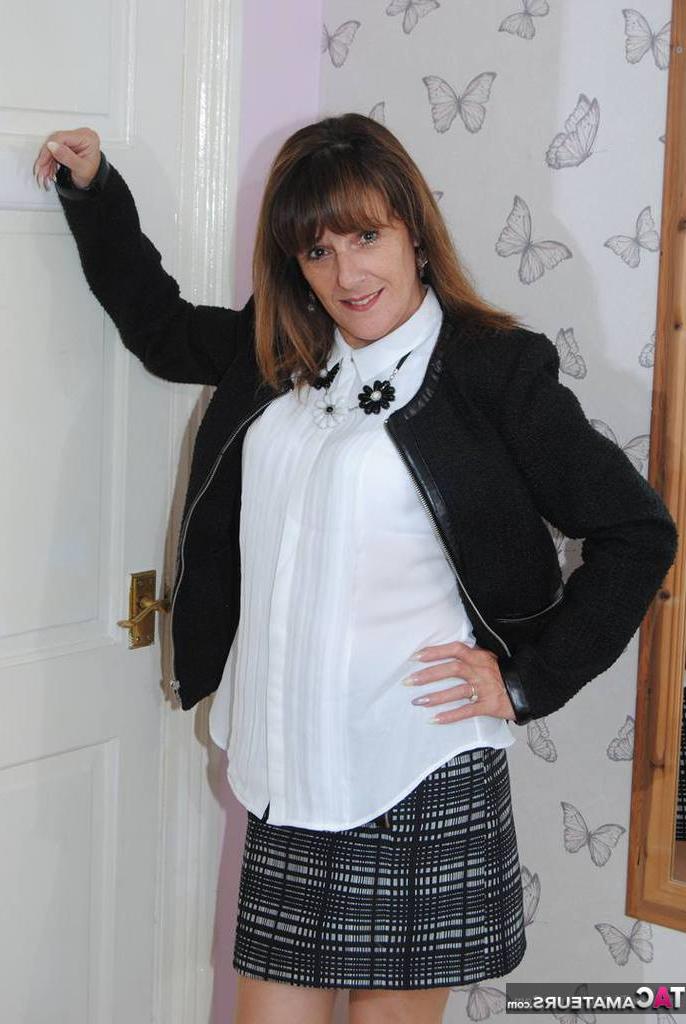 20P Señora madura se quita el suéter y la blusa blanca mientras comienza a desnudarse