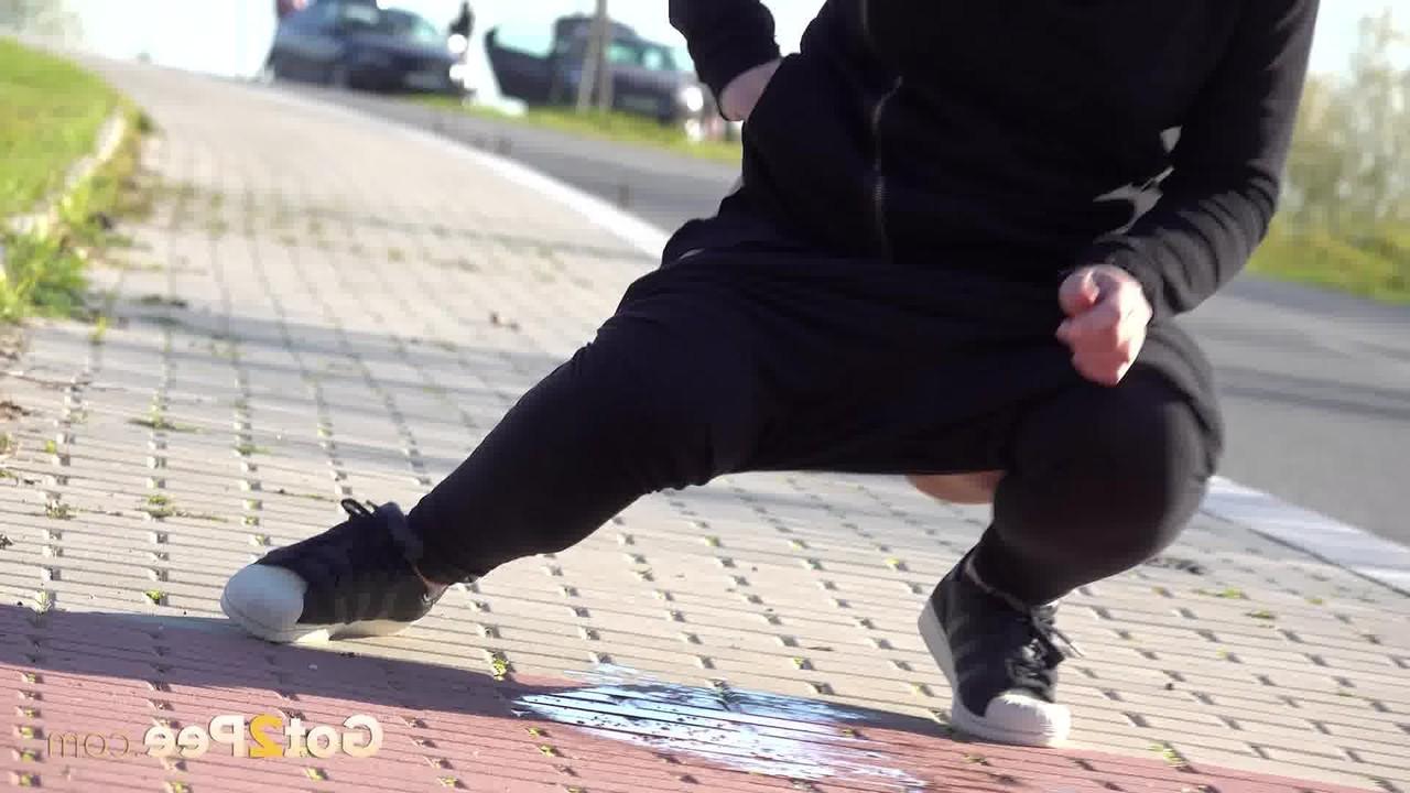 15P Caucasian girl Naomi Bennet pulls down black leggings to pee on a sidewalk