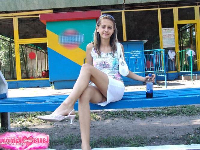 10P Uma jovem simpática pára para tomar uma garrafa de refrigerante enquanto usa uma saia justa