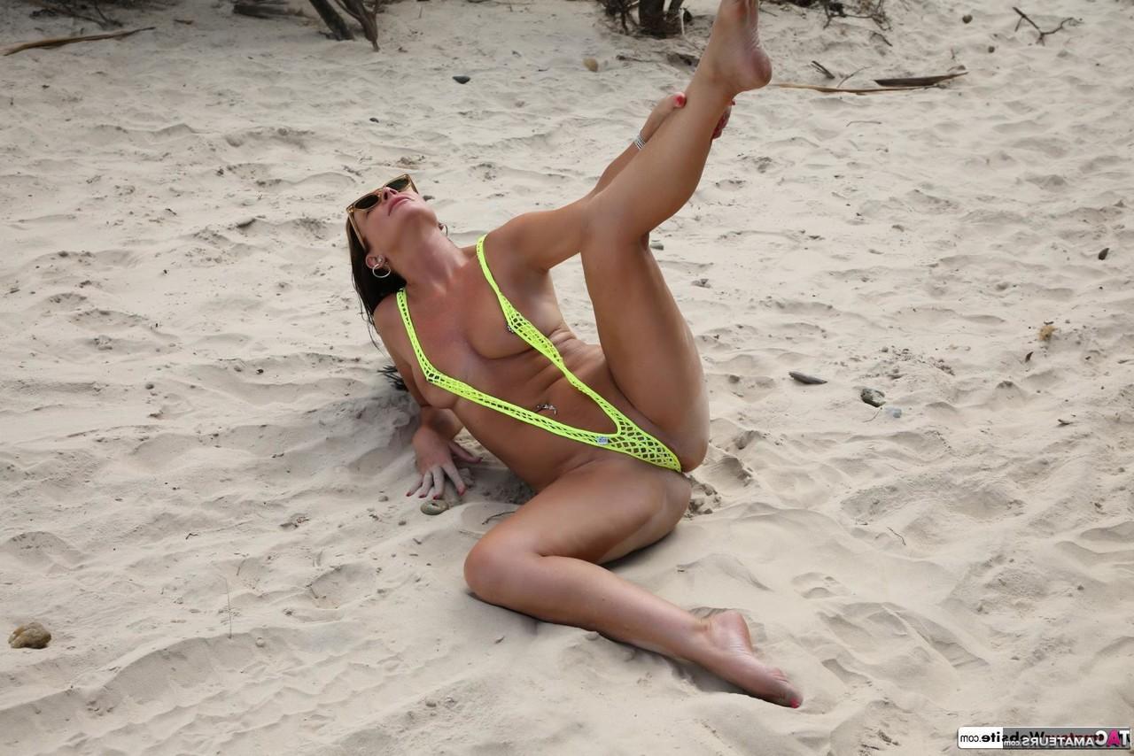 16P Brunette MILF Roxeanne takes off a V bikini on a sandy beach