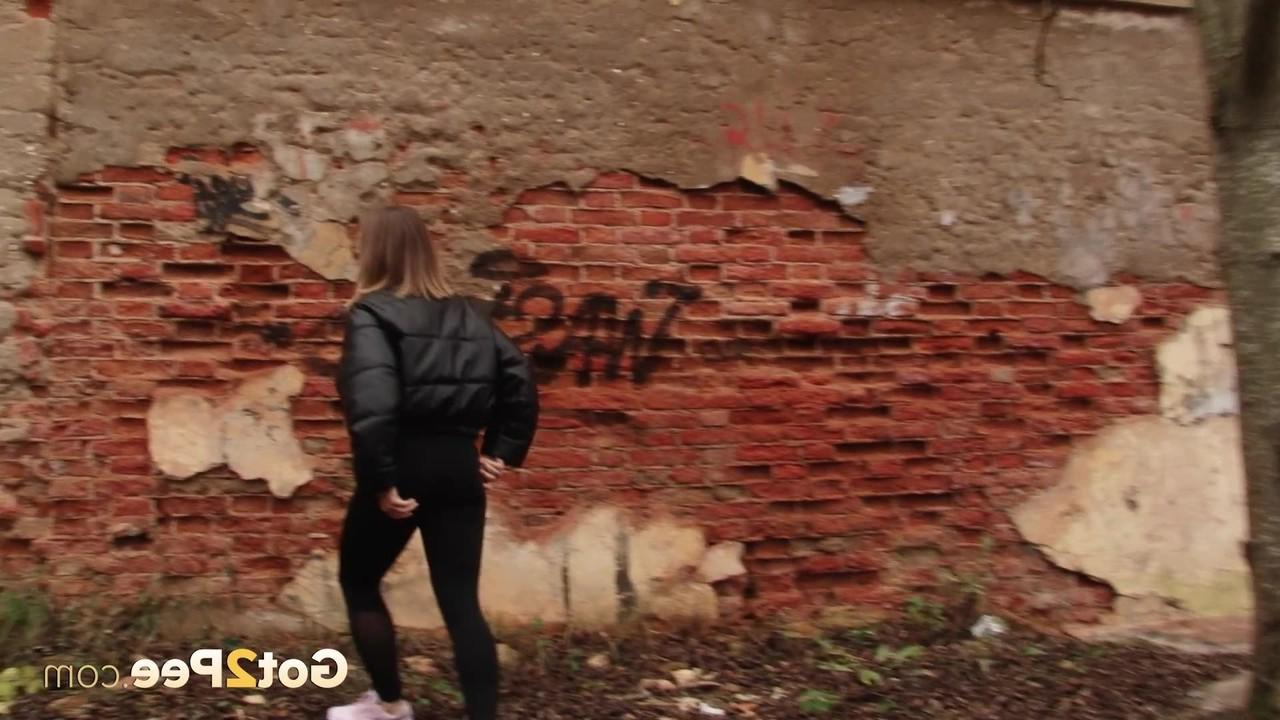 15P La linda chica Lera se baja las mallas negras para orinar detrás de un edificio en ruinas