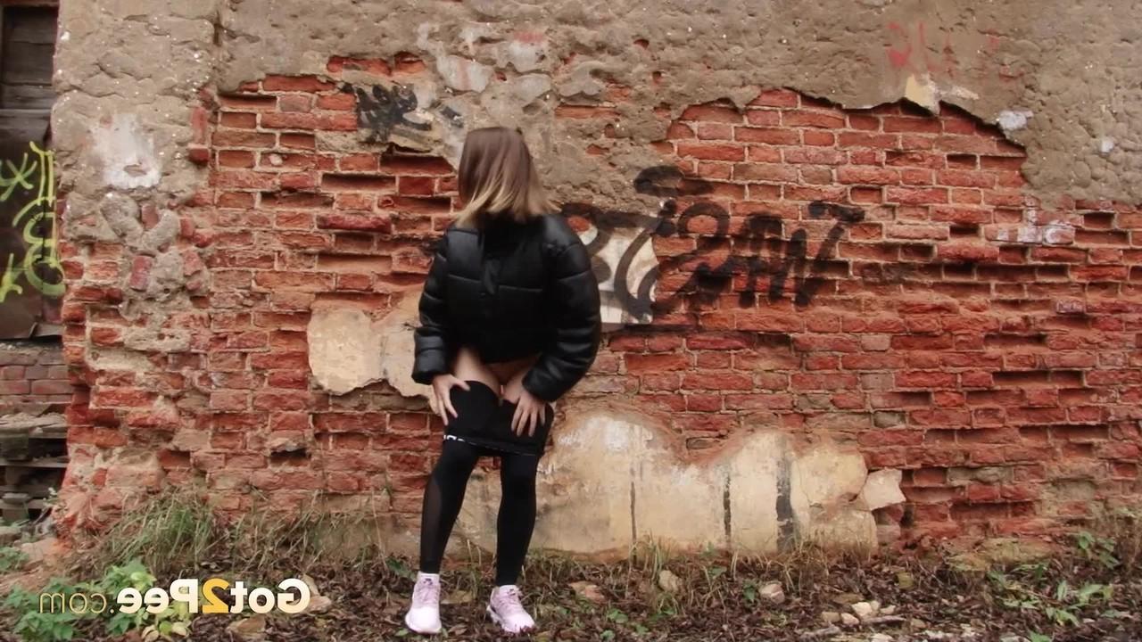15P La linda chica Lera se baja las mallas negras para orinar detrás de un edificio en ruinas