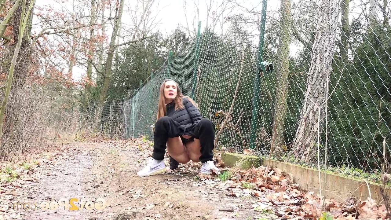 15P A garota branca Cynthia Vellons abaixa as calças para fazer xixi ao lado de uma cerca