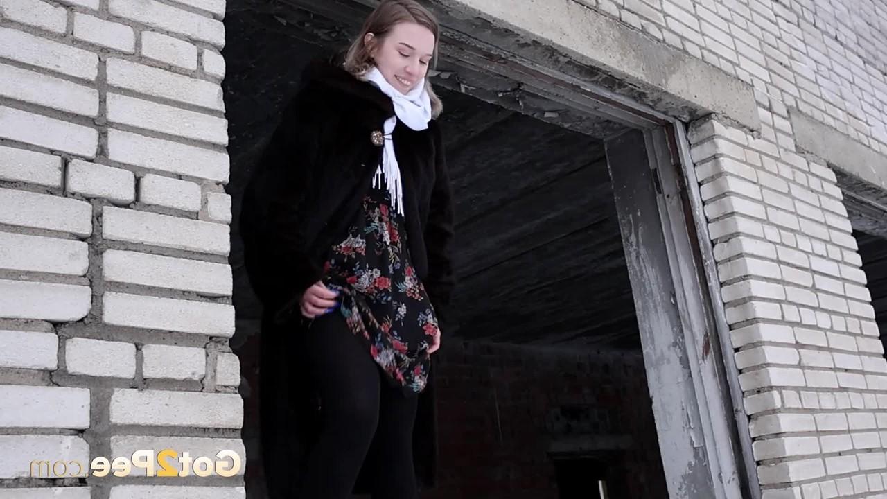 15P A loira Alice Klay mija na moldura de uma janela em um dia de inverno