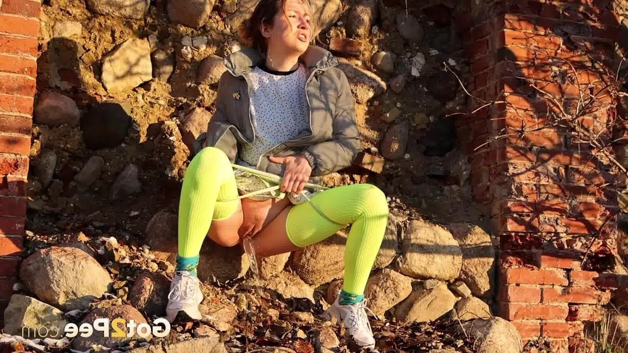 15P La chica solitaria Kaeyes orina sobre unos escombros durante el día con medias de neón