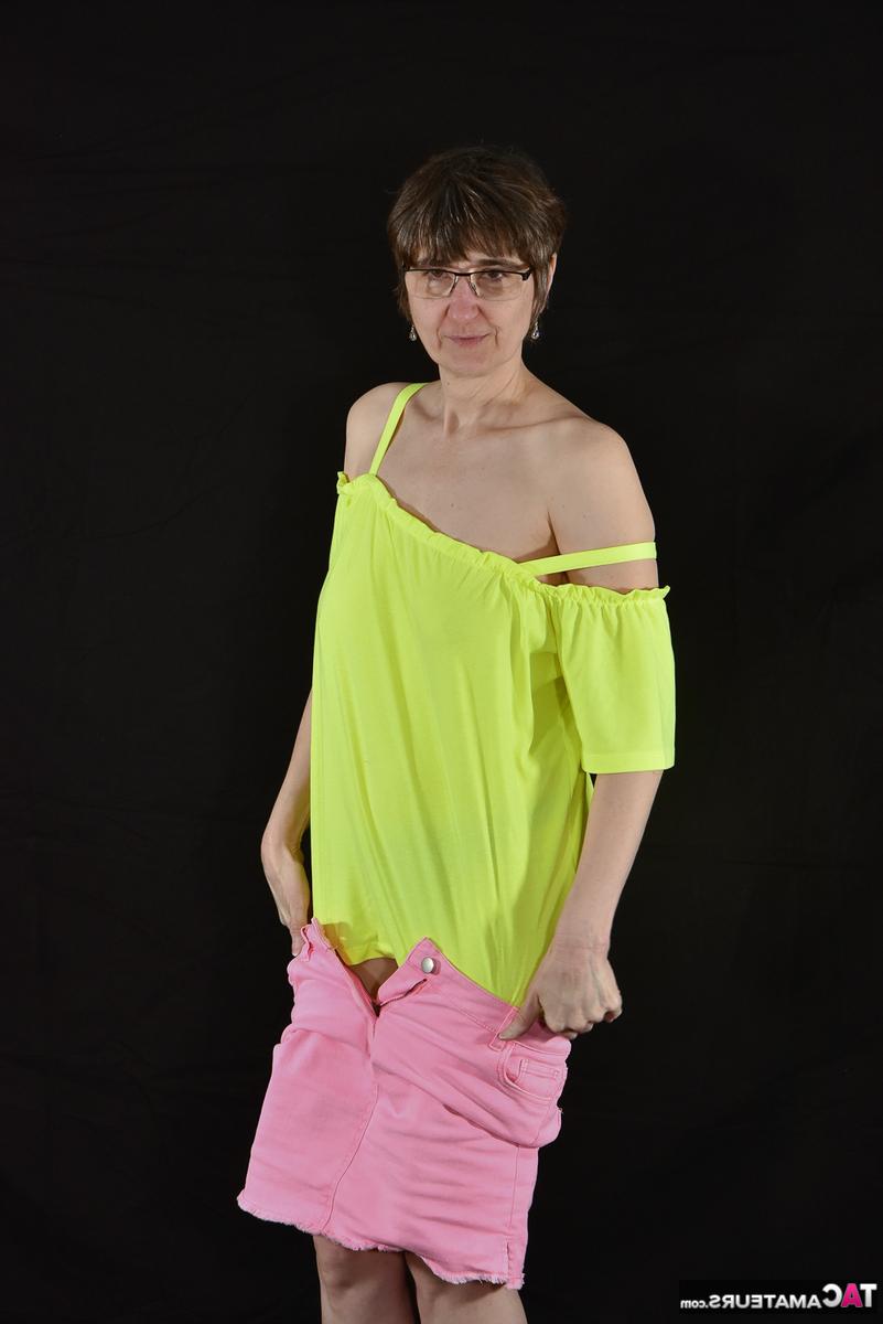 16P Die ältere Amateurin Hotmilf schlüpft aus einem rosa Rock und trägt schwarze Unterwäsche