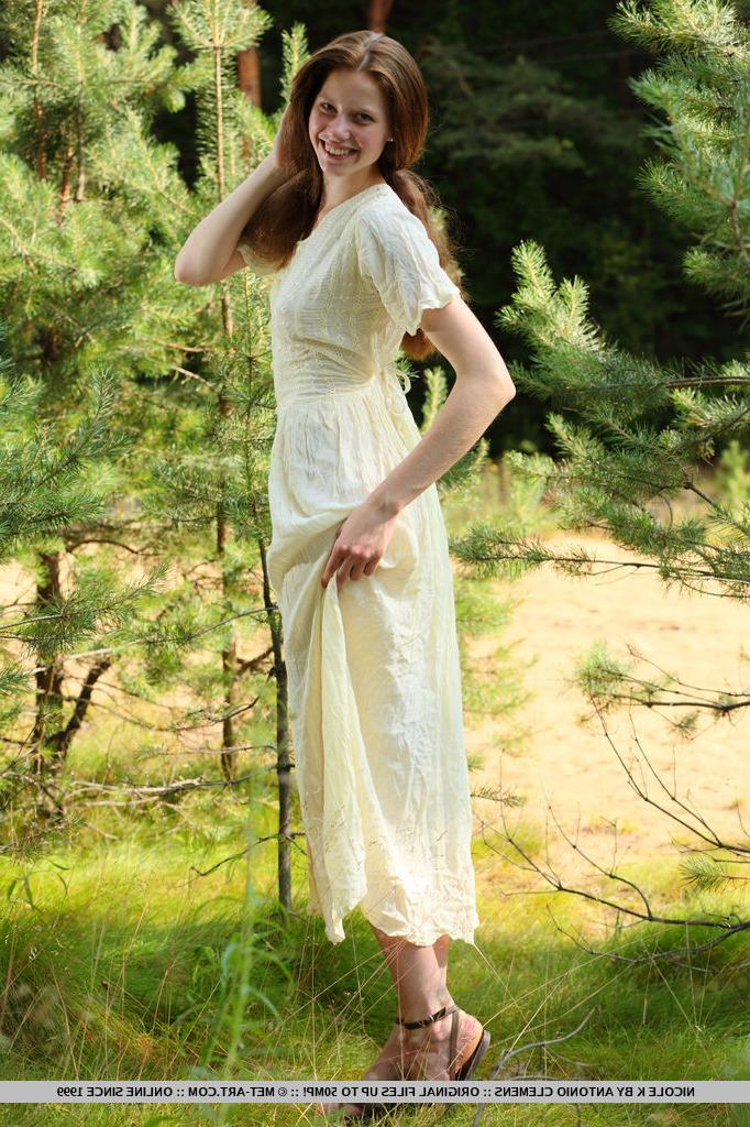 18P Nicole K, jeune fille pâle aux longs cheveux roux, se met totalement nue au milieu des jeunes arbres.