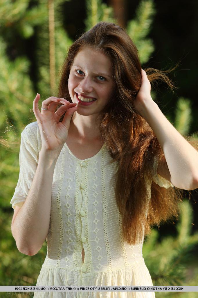 18P Nicole K, jeune fille pâle aux longs cheveux roux, se met totalement nue au milieu des jeunes arbres.