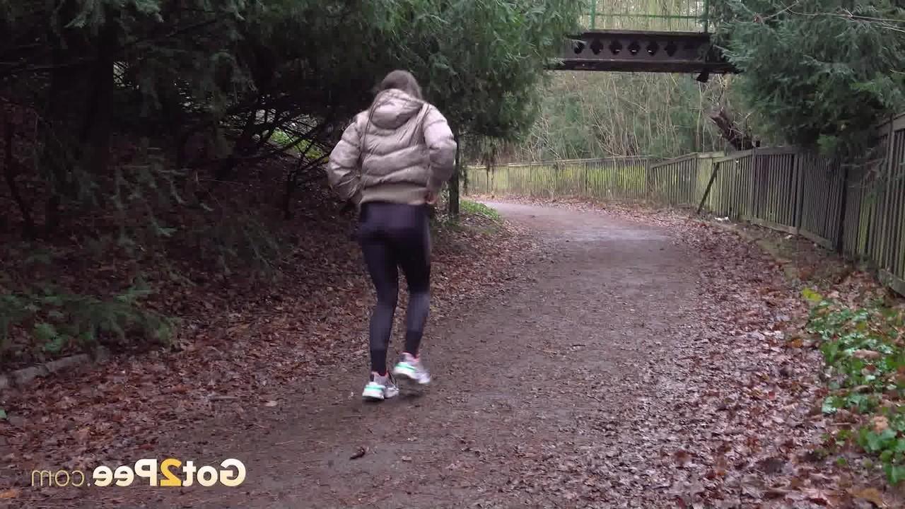 15P Das weiße Mädchen Barbara Bieber zieht ihre Leggings herunter, um neben ein paar Büschen zu pinkeln