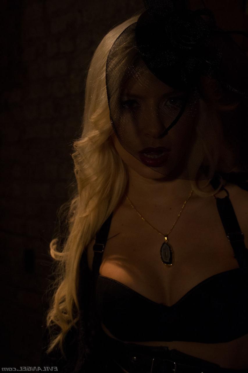 17P Blonde vampire exposes her fangs and boobs in a poorly lit cellar