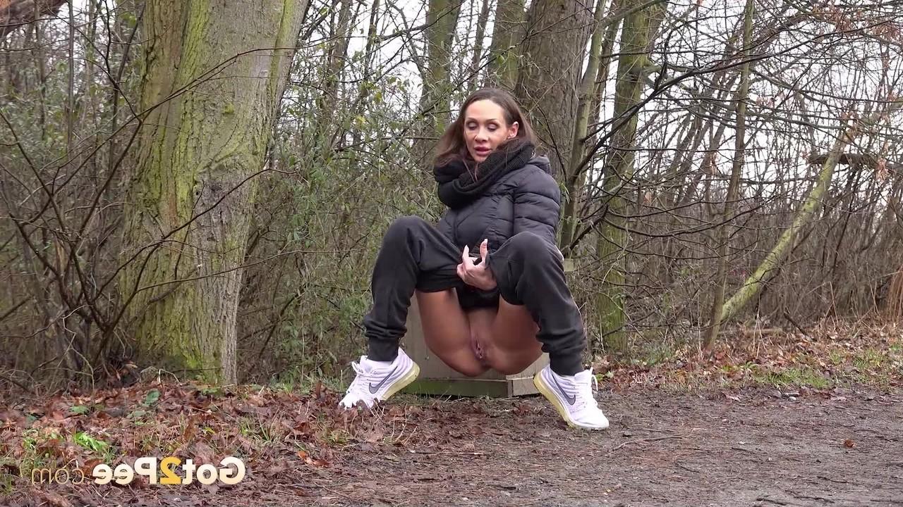 15P La MILF sexy Cynthia Vellons montre sa chatte rasée en pissant en plein air.