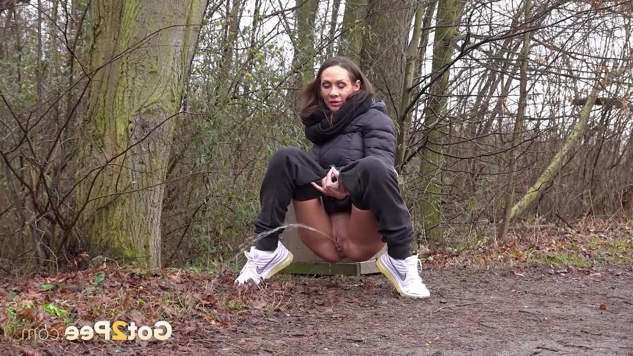 15P La MILF sexy Cynthia Vellons montre sa chatte rasée en pissant en plein air.