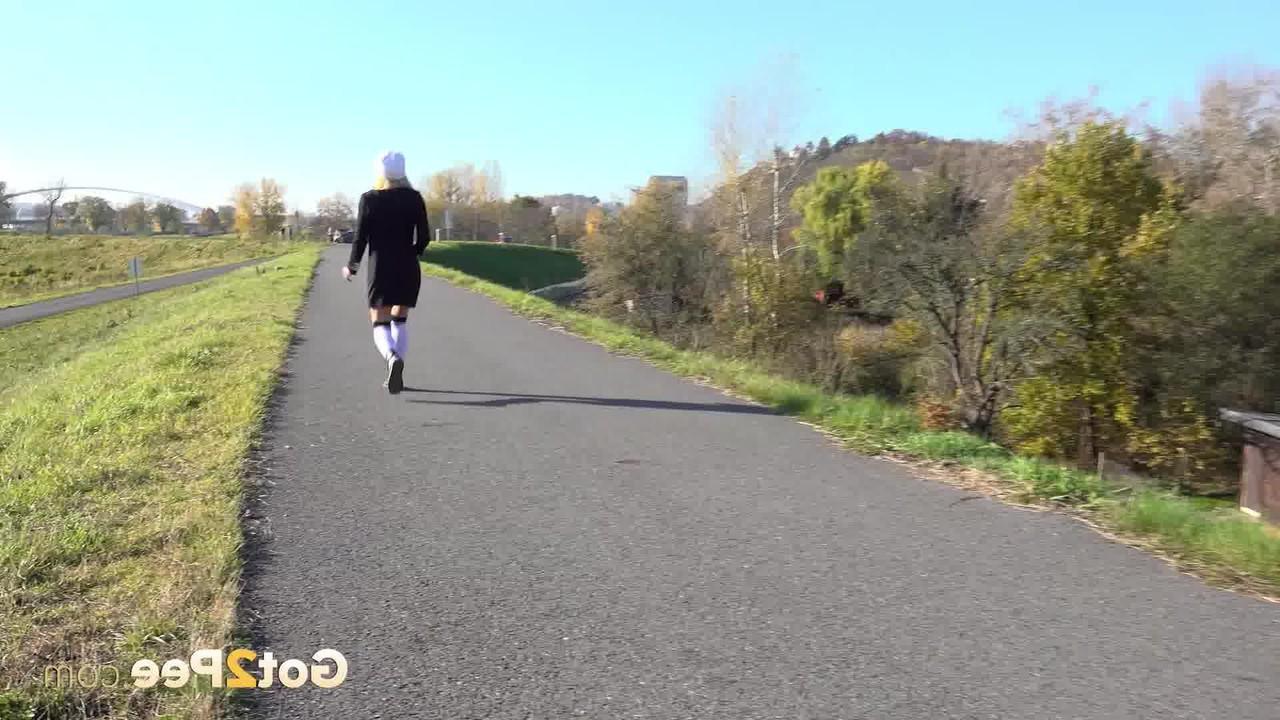 15P A loira Caroli faz xixi em um caminho pavimentado durante o dia