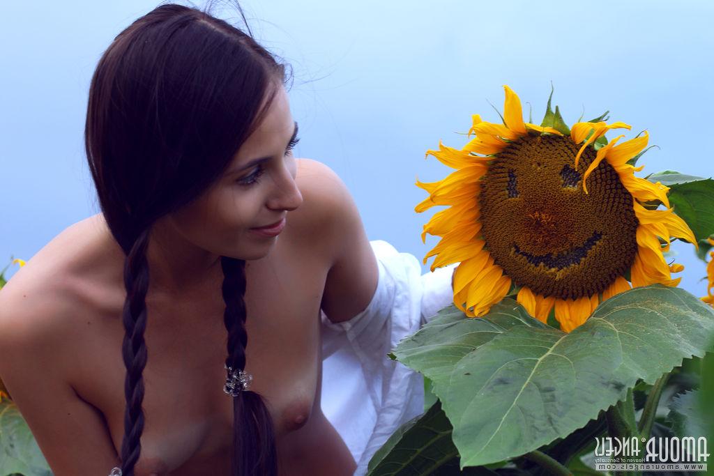 20P La jolie jeune Vanessa se met nue dans un champ de tournesols tout en arborant des nattes.