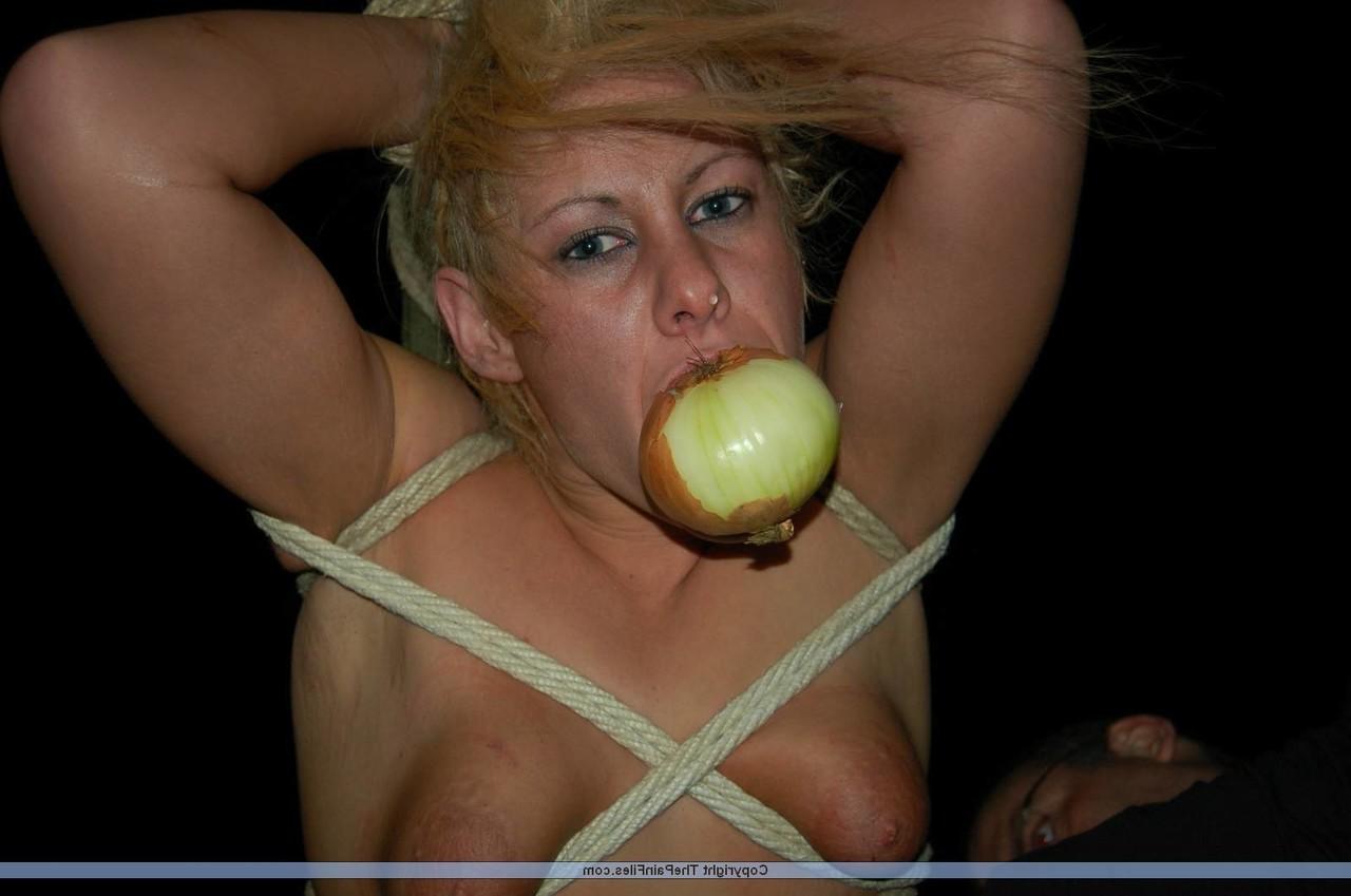 16P Rubia desnuda con una manzana en la boca es asada al fuego mientras está atada con una cuerda