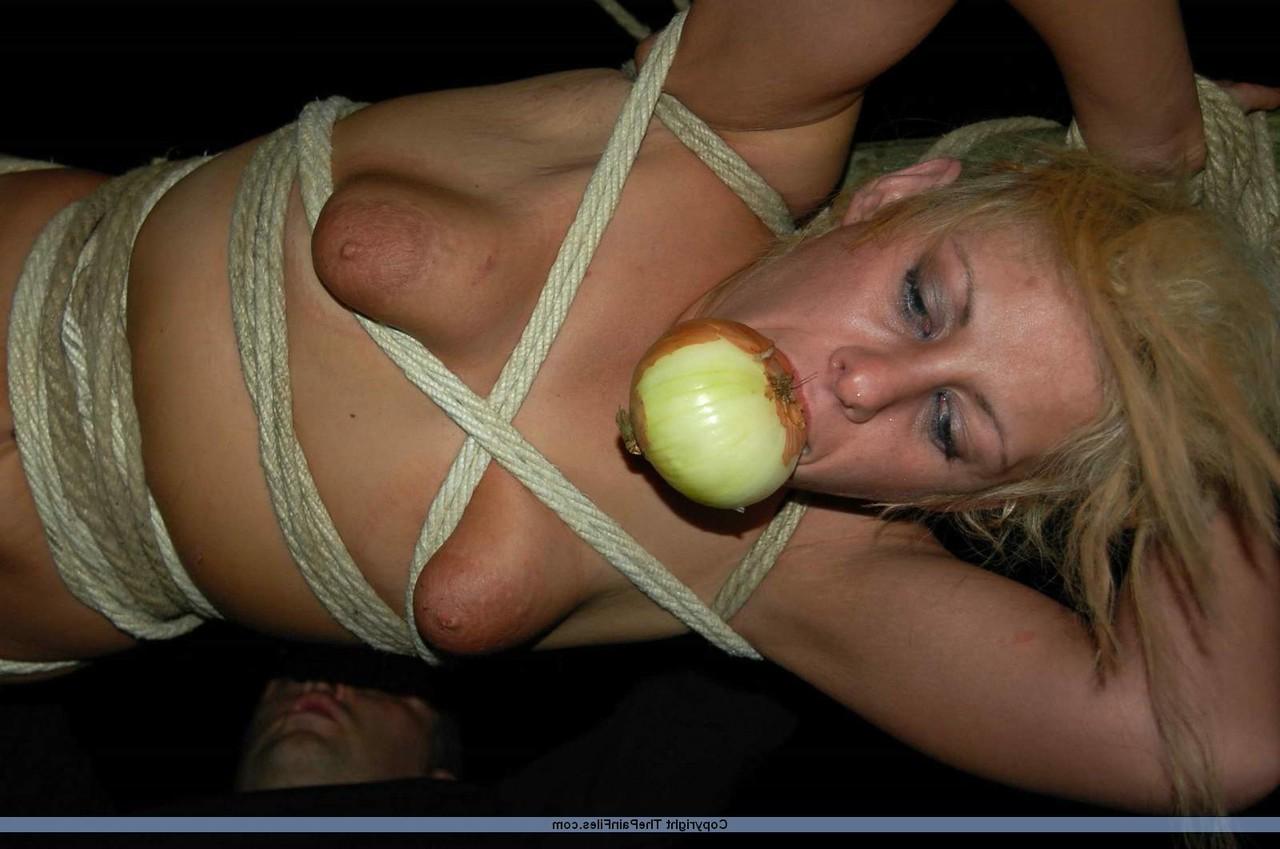 16P Rubia desnuda con una manzana en la boca es asada al fuego mientras está atada con una cuerda