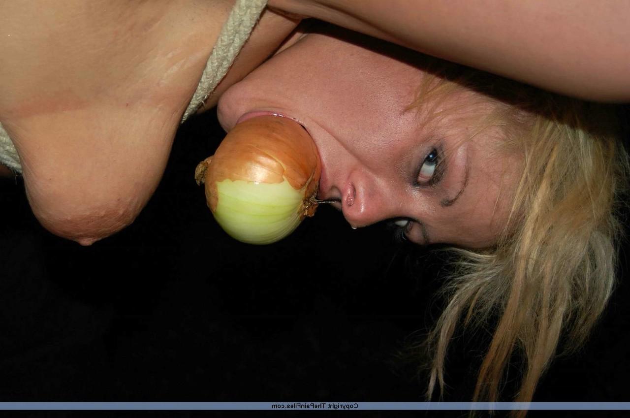 16P Rubia desnuda con una manzana en la boca es asada al fuego mientras está atada con una cuerda
