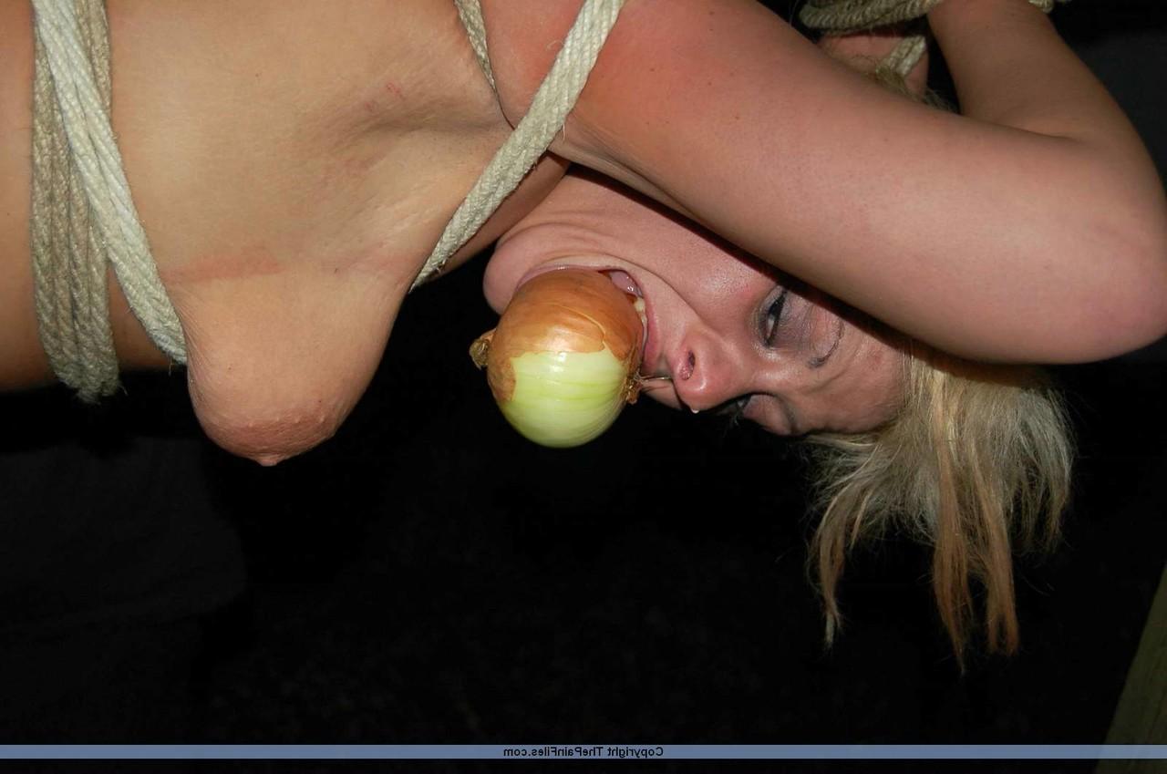 16P Rubia desnuda con una manzana en la boca es asada al fuego mientras está atada con una cuerda