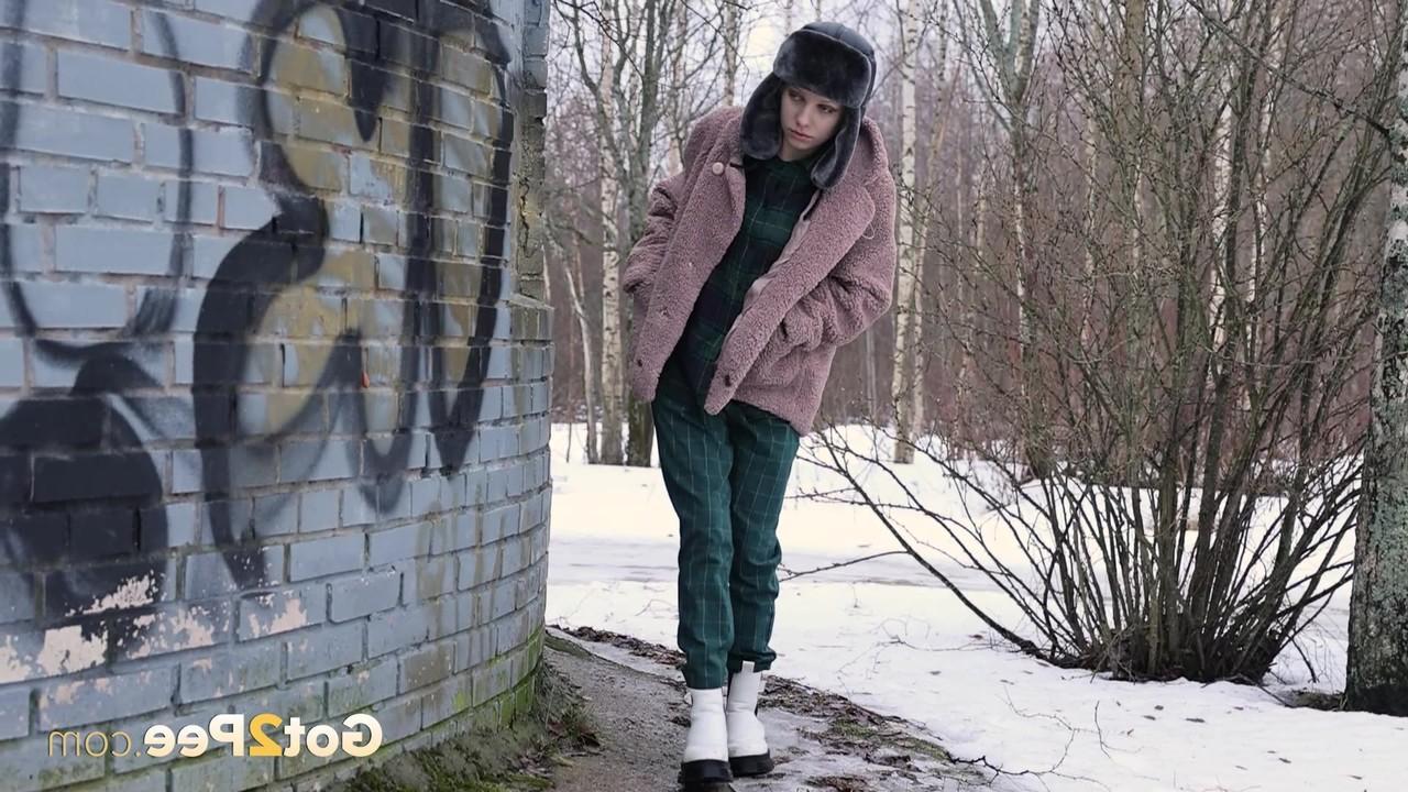 15P Caucasian girl Vasya pisses up against a brick wall in winter clothing