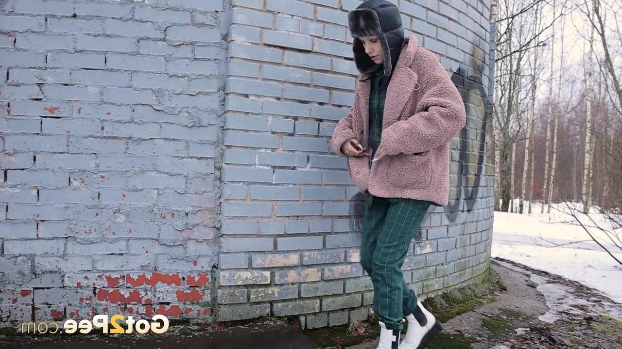 15P Caucasian girl Vasya pisses up against a brick wall in winter clothing