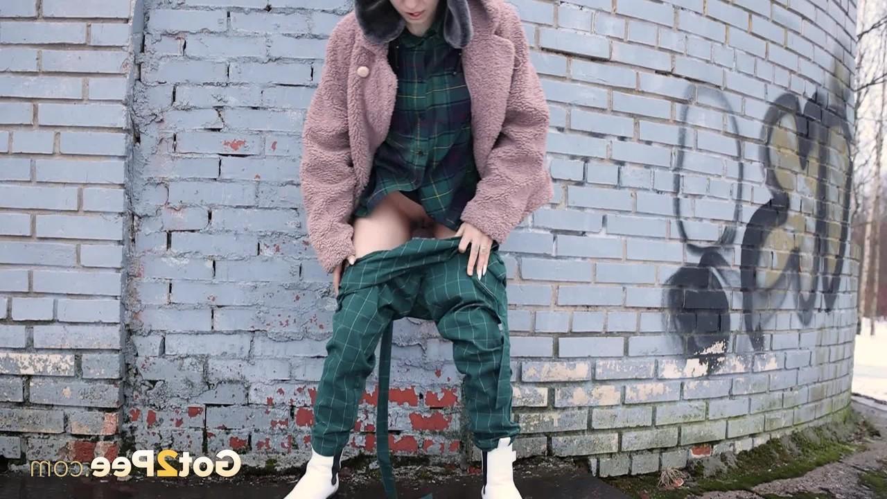 15P Caucasian girl Vasya pisses up against a brick wall in winter clothing