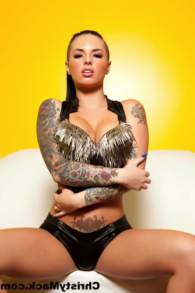 15P La star du porno tatouée Christy Mack caresse ses seins ronds et écarte sa chatte.