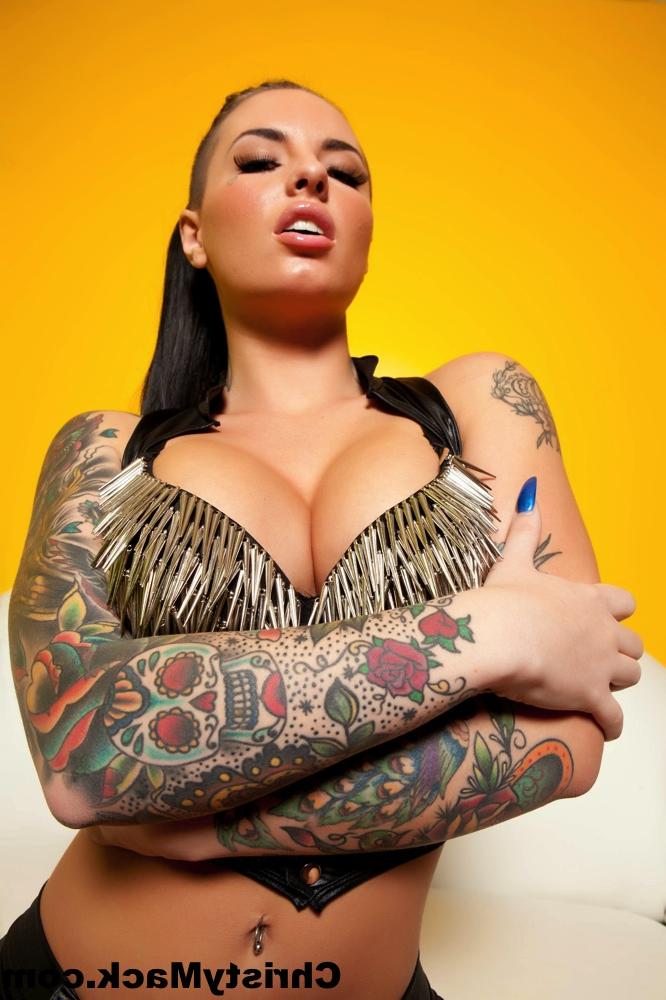 15P La star du porno tatouée Christy Mack caresse ses seins ronds et écarte sa chatte.