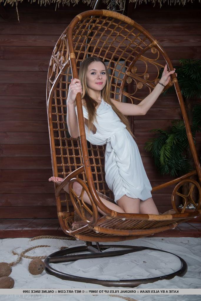 18P Katie A, jeune aux cheveux longs, se met totalement nue dans un fauteuil suspendu.