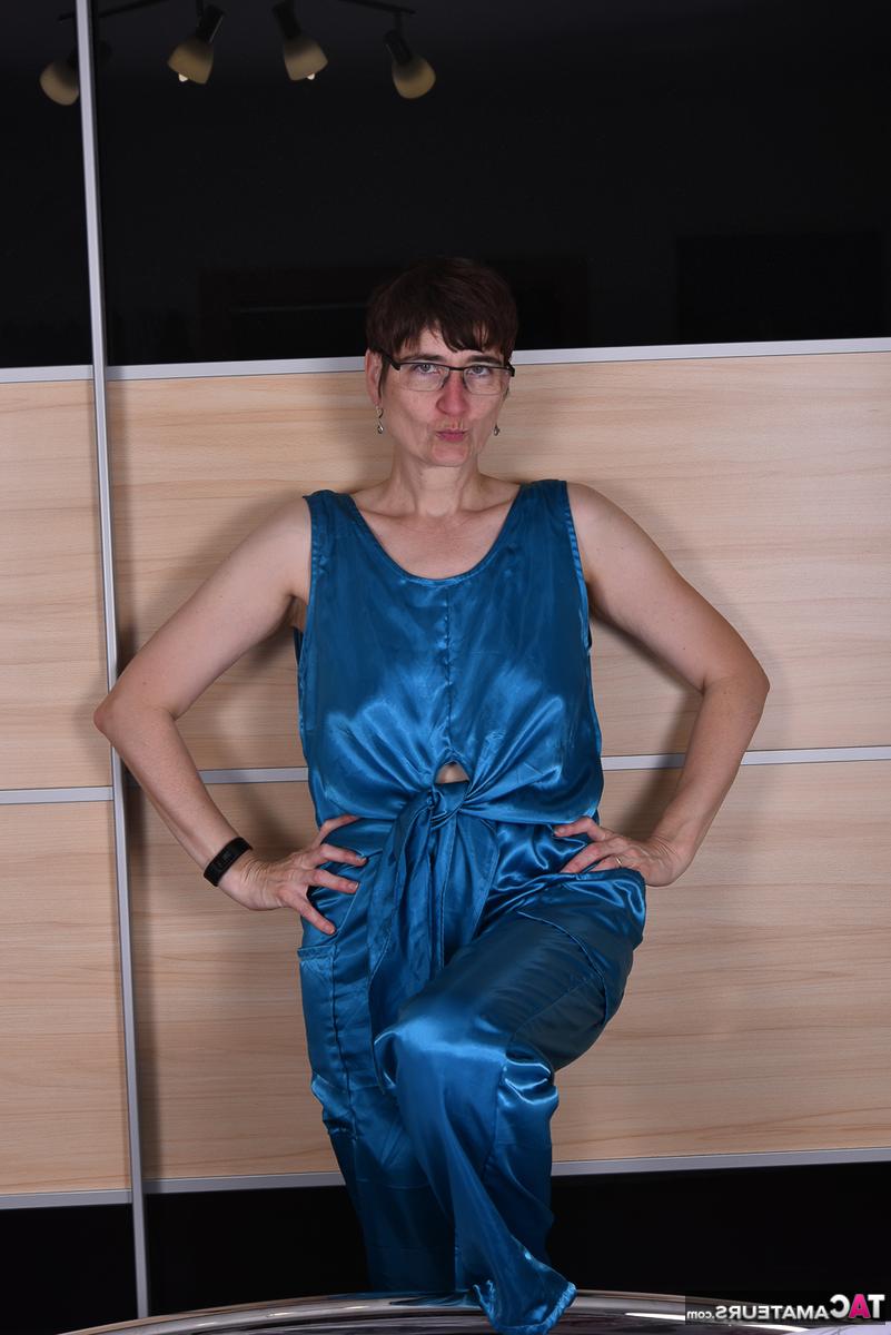 16P Mulher amadora modela roupas de noite de cetim em uma cama com óculos