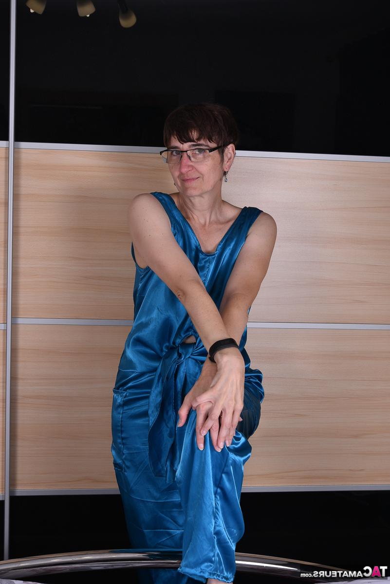 16P Mulher amadora modela roupas de noite de cetim em uma cama com óculos
