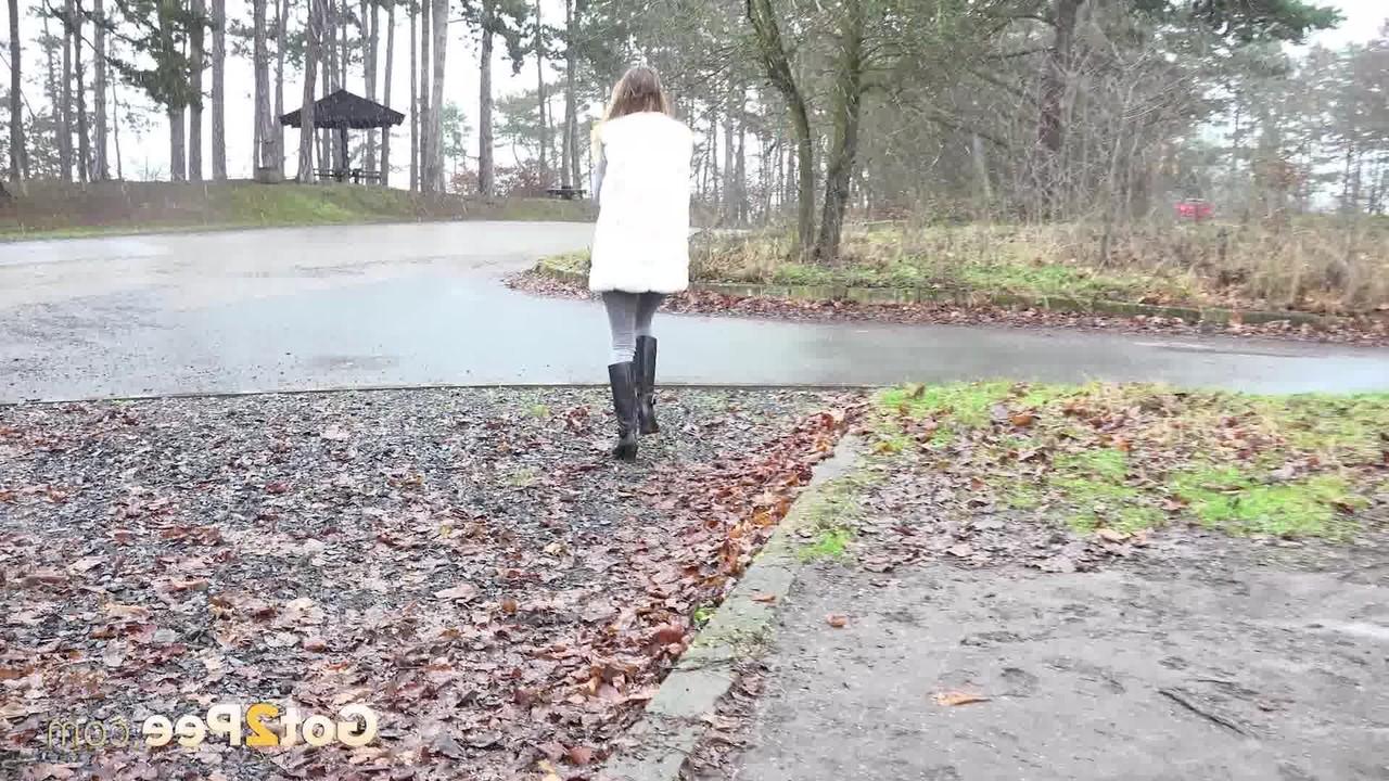 15P Das Solo-Girl Cynthia Vellons pisst an einem nassen Tag in eine Kiesauffahrt