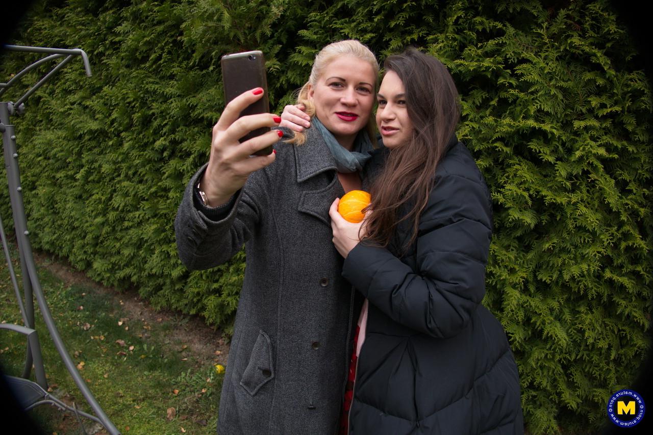 16P Une lesbienne blonde mature et une jeune brune partagent un gode à double extrémité