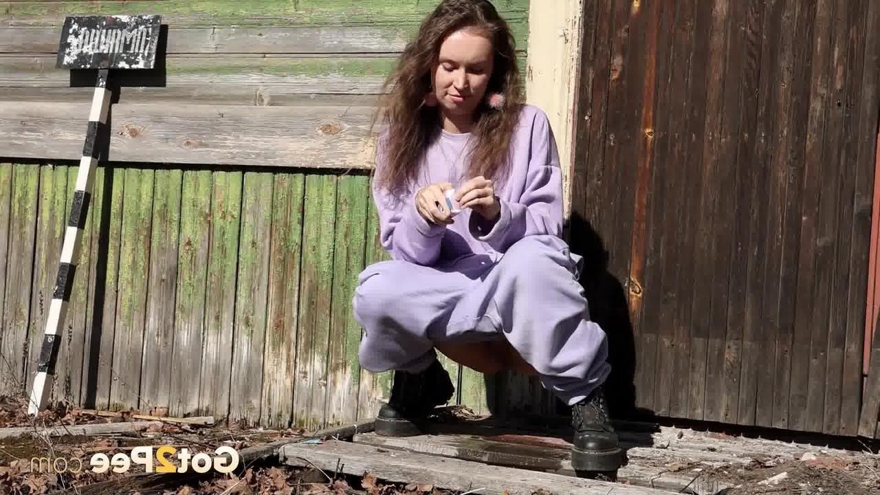 15P Nikky B takes a badly needed pee on the back porch of a rustic dwelling
